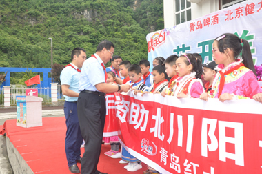健力源集团工会副主席战桂华给孩子们发放助学金